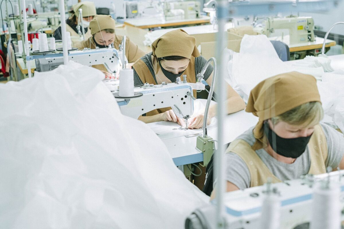 Workers at sewing machines on a factory production line